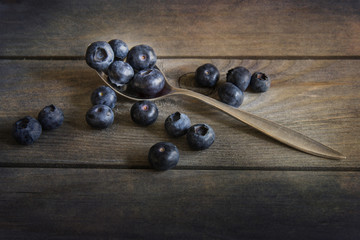 Blueberries in rustic kitchen setting with old wooden background