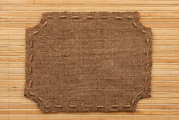 Frame of burlap, lies on a background of  bamboo mat
