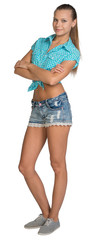 Pretty girl in shorts and shirt standing with crossed arms