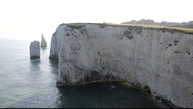 Tiny people big chalk cliffs Studland Dorset England UK