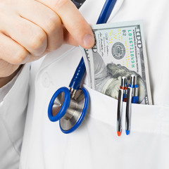 Medical doctor insurting money into his pocket - studio shoot