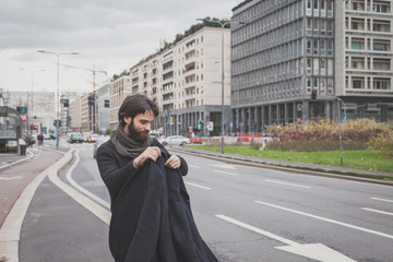Fototapeta premium Young handsome bearded man posing in the city streets