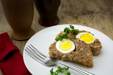 baked meatloaf with boiled eggs for Easter on rustic wood