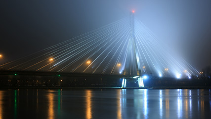 Suspension bridge in the fog. Warsaw by night, bridge Swietokrzy