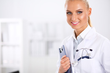 Smiling female doctor with a folder in uniform standing at