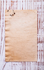 old blank sheet of paper on wooden board with copyspace for your