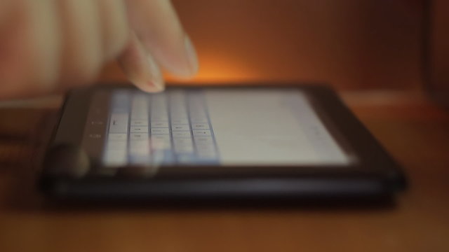 Close-up of hands using digital tablet