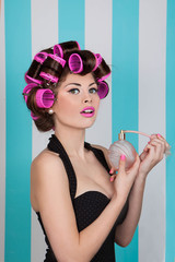 retro pin up girl spraying perfume with hair rollers