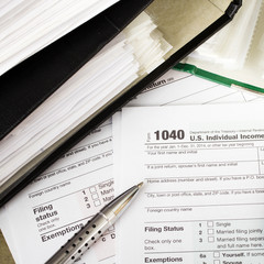 Close up U.S. Individual tax form 1040 with calculator and pen.