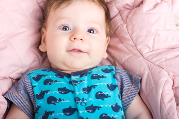 Cute baby in a pink bed. Portrait of a baby.