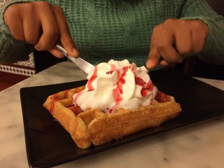 mujer disfrutando un delicioso wofre con nata de postre