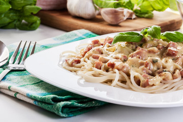 Spaghetti carbonara with bacon and basil