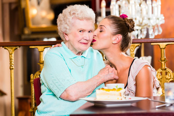 Großmutter und Enkelin bei Kuchen im Cafe