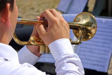 Musician playing on trumpet in street orchestra