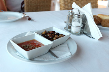 bottle wooden spoon with olives on a table