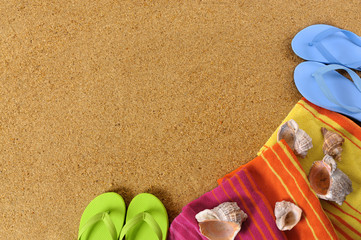 Beach sand background with flip flops towel and seashells summer holiday vacation photo