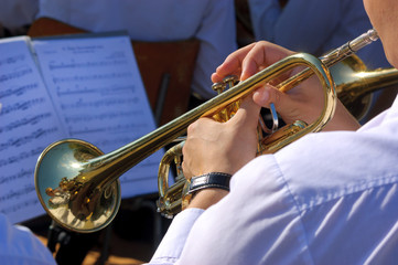 Musician playing on trumpet in the street orchestra