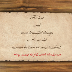 Inspirational quote on  grunge paper against wood background