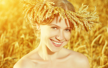 beautiful happy girl in wreath in wheat field in summer