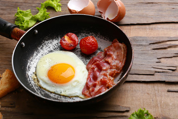 Bacon and eggs on rustic wooden planks background