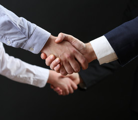 Business handshake on dark background