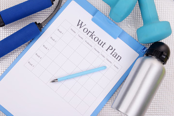 Workout plan and sports equipment top view close-up