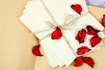 Love letters and rose petals on wooden background