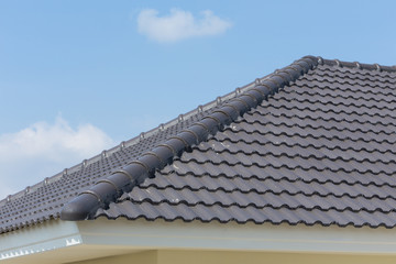 black roof tiles on house with blue sky