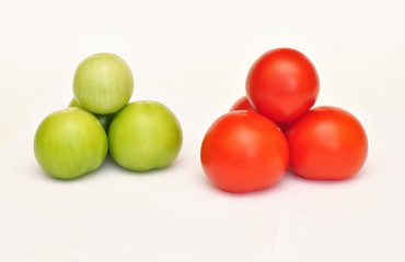 Pyramid of fresh green and red tomato on white background