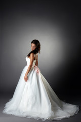 Fototapeta na wymiar Modest bride posing in elegant dress with plume