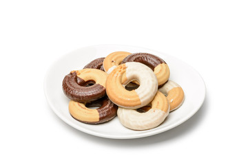 Ring shaped chocolate biscuits in a porcelain plate isolated on white background