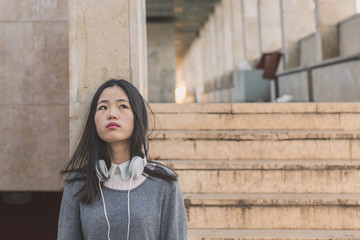 Young beautiful Chinese girl posing in the city streets