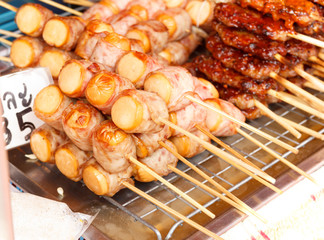 Grilled bacon wrapped sausage skewers
