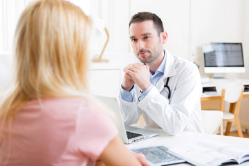 Fototapeta na wymiar Young attractive doctor listening his patient