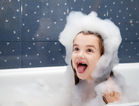 surprised little girl sitting in a bath