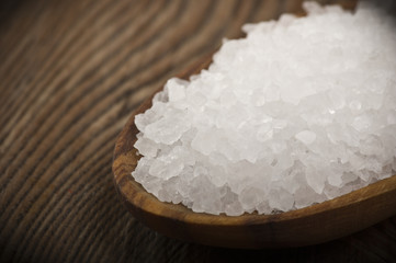 spoon with sea salt on wood table