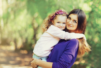 Fototapeta premium Portrait of happy young mother and cute child outdoors