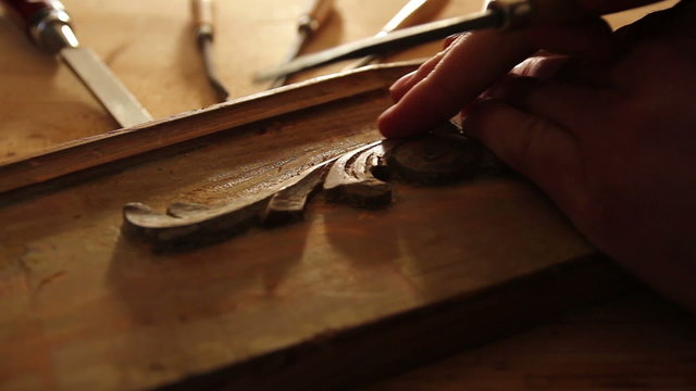 Close up of  carpenter restoring old furniture with chisel.