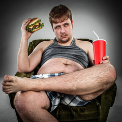 Fat man eating hamburger © Andrei Armiagov