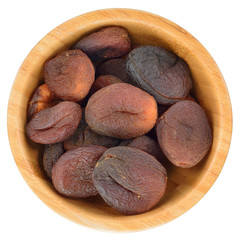 Sun dried apricots in wooden bowl isolated.