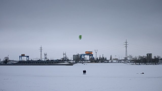 Family using a kite on frozen water storage reservoir