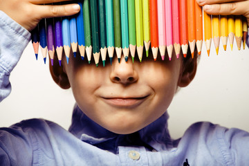 little cute boy with color pencils close up smiling