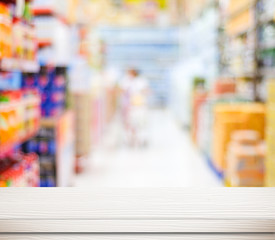 Empty white table over blur supermarket with bokeh background