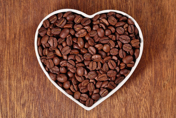 Coffee beans in plate in the form of heart