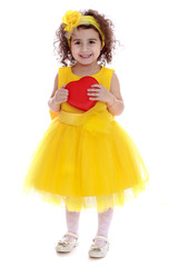 Beautiful curly-haired little girl in a yellow dress cuddle hear