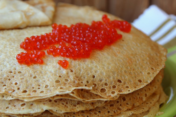 Stack of pancakes and red caviar.