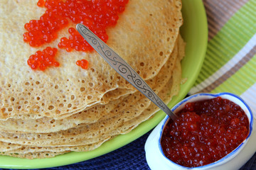 Stack of pancakes and red caviar.