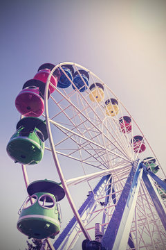 Retro filtered picture of ferris wheel in a n amusement park.