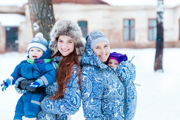 Happy mothers and babys playing on snow