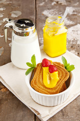 Breakfast with toast, lemon curd and ripe berries, milk.